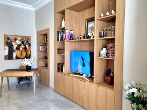 a living room with a book shelf with a tv at Hotel Carlton Nice in Nice
