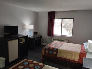 a hotel room with a bed and a television at Super 8 by Wyndham Morris in Morris +19 photos
