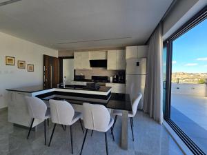 a kitchen with white chairs and a large kitchen island at Villa rooftop with stunning view apartment in Amman