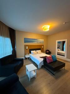 a hotel room with a bed and a couch at City Hotel Plovdiv FREE PARKING in Plovdiv