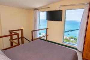 a bedroom with a bunk bed and a large window at Pousada Colonial Chile in Salvador