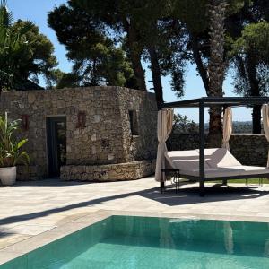 a patio with a bed and a swimming pool at Sa Suites in Trepuzzi
