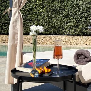 a table with a vase of flowers and a glass at Sa Suites in Trepuzzi