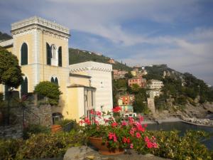 une église avec des fleurs devant une rivière dans l'établissement Castello Canevaro, à Zoagli