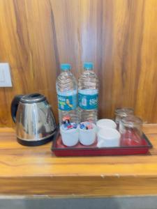 a tray with two bottles of water and bowls on a shelf at MADHUBAN STAYS rishikesh in Rishīkesh