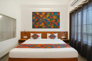 a bedroom with a bed and a painting on the wall at MADHUBAN STAYS rishikesh in Rishīkesh