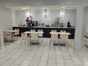 a kitchen with tables and chairs in a kitchen at Super 8 by Wyndham Morris in Morris