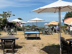 a group of tables and chairs with umbrellas at Liten stuga med havsutsikt in VBY