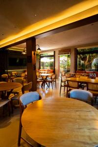 a restaurant with wooden tables and chairs and tables at Hotel das Palmeiras in Paracatu