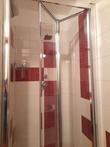 a shower in a bathroom with red and white tiles at Villetta Eden Schilpario in Schilpario
