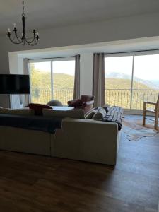 a living room with two couches and a large window at Villa avec vue et piscine privée in Moltifao
