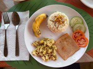 a plate of food with a banana and rice at EL-NARA SEASIDE Beach Resort in El Nido