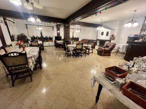 a large room with tables and chairs and a living room at Casa De Vis in Arieşeni