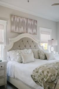 a white bedroom with a large bed with a large headboard at Coastal Quarters Condo in Bluffton