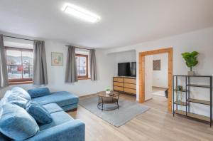 a living room with a blue couch and a tv at Easy City Apartments in Reutte