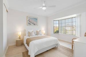 a white bedroom with a bed and a window at The Water House - Lakeside Serenity & Modern Comfort in Encounter Bay