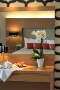 une chambre d'hôtel avec un lit et une table avec de la nourriture dans l'établissement Elektra Hotel & Spa, à Kalamata