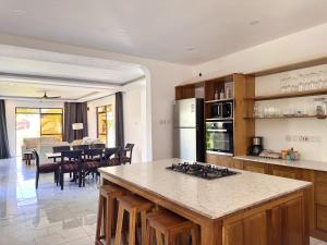 a kitchen and dining room with a table and a counter at Villa Samara - 10p - 5bdr - Diani Beach - Piscine in Magutu