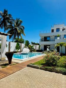a swimming pool in front of a building at Villa Samara - 10p - 5bdr - Diani Beach - Piscine in Magutu