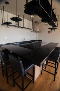 a kitchen with a large black table and chairs at Studio Exclusivo in Cuiaba 1711 in Cuiabá +2 photos
