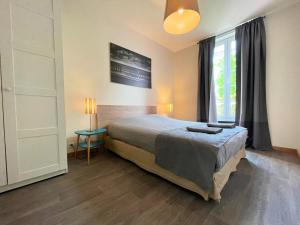 a bedroom with a large bed and a window at Villa LES MYRTILLES in Cabourg