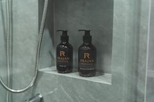 two bottles of soap sitting on a shelf in a shower at Prajan Residence in Buriram +35 photos