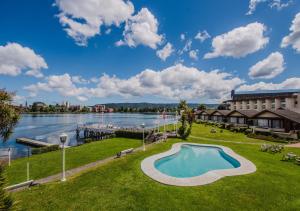ein Bild eines Ferienresorts mit Schwimmbad und See in der Unterkunft Hotel Marina Villa del Rio in Valdivia