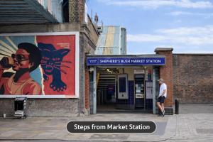 a man standing in front of a market station with a painting at Abbey Hotel, London Shepherd's Bush in London