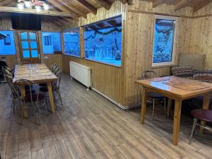 a dining room with wooden tables and chairs at Casa Moșoiu in Bran