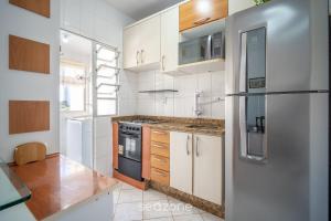 a kitchen with white cabinets and a refrigerator at 1-Bedroom Apt in Floripa OAN0305 in Florianópolis