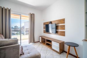 a living room with a tv on a wall at 1-Bedroom Apt in Floripa OAN0305 in Florianópolis