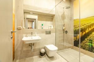 a bathroom with a toilet and a sink and a shower at 1 BR Wine Journey in Sofia +10 photos