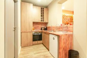 a small kitchen with wooden cabinets and a sink at 1 BR Wine Journey in Sofia