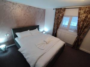 a bedroom with a white bed and a window at Casa Aida in Peşteana