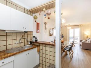 a kitchen with white cabinets and a living room at Apartment Platja Mar by Interhome in L'Escala