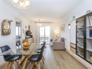 a dining room and living room with a glass table and chairs at Apartment Platja Mar by Interhome in L'Escala +18 photos