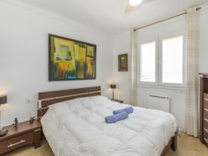 a bedroom with a large white bed and two windows at Apartment Platja Mar by Interhome in L'Escala