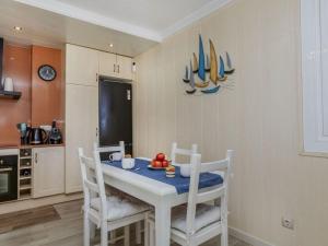 a kitchen with a white table with chairs and a table with fruit on it at Apartment Xaloc by Interhome in Cubelles