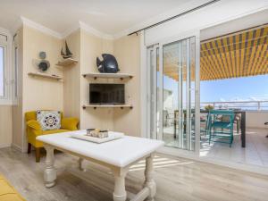 a living room with a table and a view of the ocean at Apartment Xaloc by Interhome in Cubelles