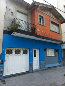 a blue and white house with white garage doors at Casona Sol in Mar del Plata
