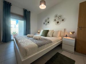 a large white bed in a bedroom with a window at John Shelter in Portimão