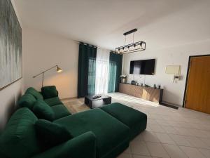 a living room with a green couch and a television at John Shelter in Portimão
