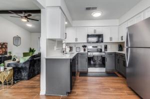 a kitchen with white cabinets and a stainless steel refrigerator at Maison Noir Retreat 3B 2B KING in Richardson