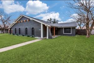 a gray house with a grass yard at Maison Noir Retreat 3B 2B KING in Richardson