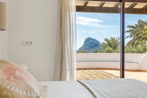 a bedroom with a window with a view of the ocean at UNIO Ibiza - Adults Only in Cala Vadella