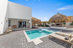 a villa with a swimming pool and a patio at Cura Kaat - Ruime 4 slaapkamer villa met zwembad op gated resort in Jan Thiel