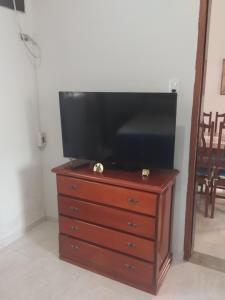 a flat screen tv sitting on top of a dresser at Bonito é ser Feliz Budget in Recife