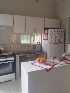 a kitchen with white cabinets and a bowl of fruit on a counter at Bonito é ser Feliz Budget in Recife