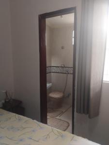 a bedroom with a bathroom with a toilet and a mirror at Bonito é ser Feliz Budget in Recife +7 photos