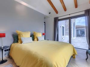 a bedroom with a large yellow bed and a balcony at Villa Maison Paradis by Interhome in Višnjan